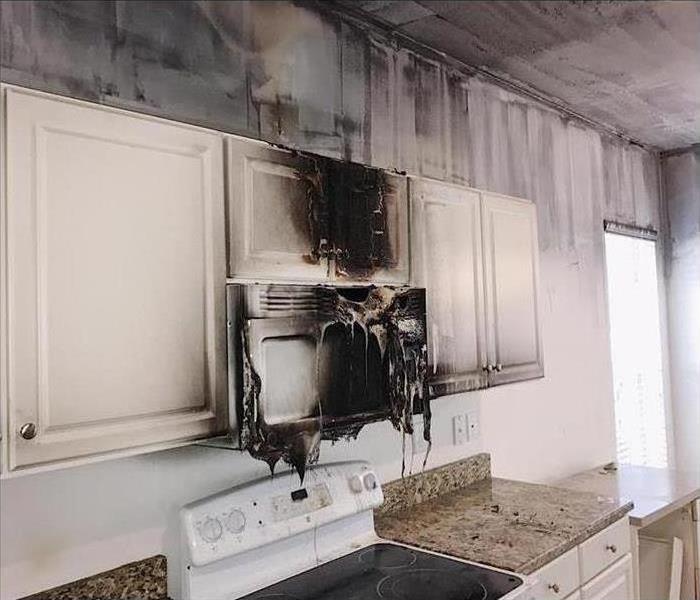 Fire damage in kitchen melted microwave and cabinets