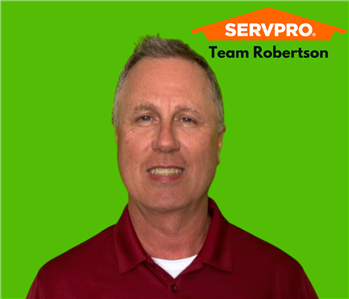 Smiling man on green background with a SERVPRO logo 
