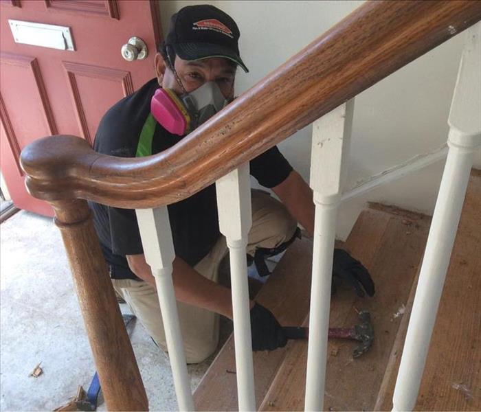 Technician with hammer on the bottom of stair case